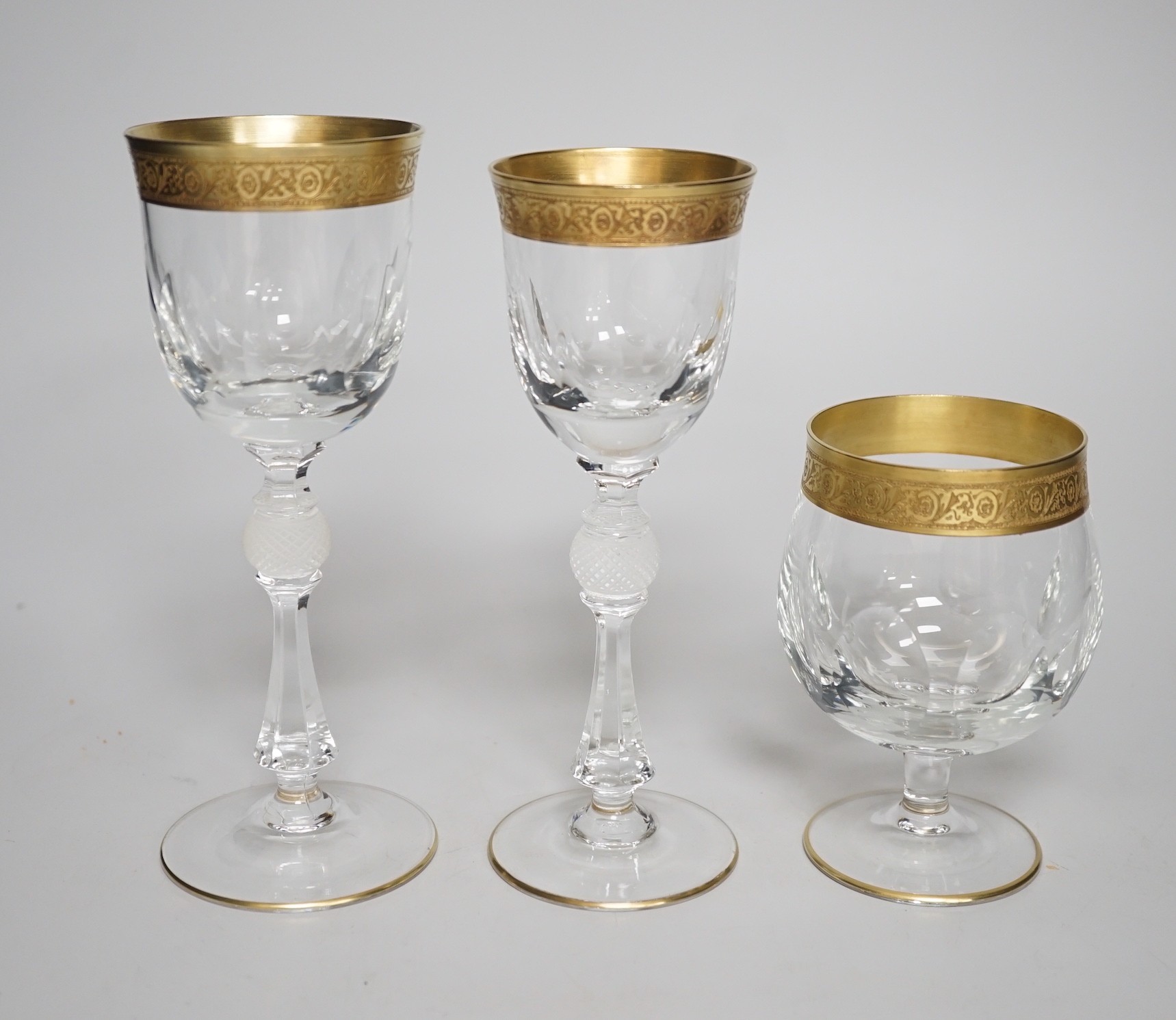 A Harrods retailed parcel gilt and cut and moulded suite of drinking glasses, two decanters and two carafes
